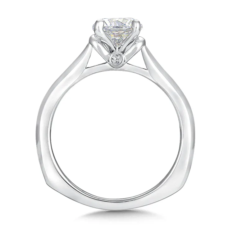 A polished cape design with surprise diamond adds a modern touch to this classic solitaire ring.